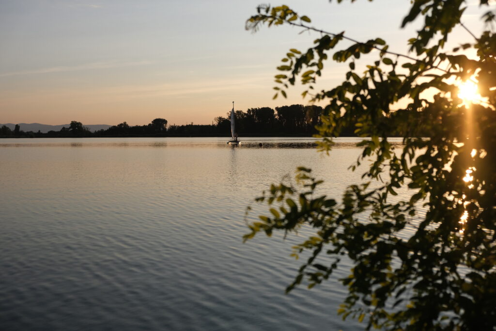 bateau à voile sur un lac paisible au coucher de soleil