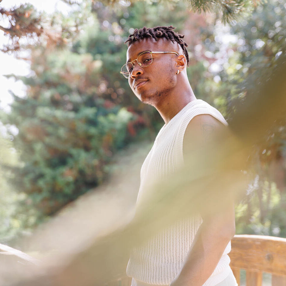 jeune homme pris en transparence d'une branche d'arbre